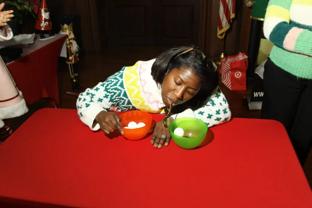 Employee plays a minute-to-win-it game at an office Christmas party