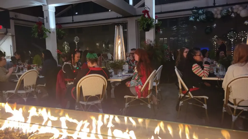 Guests seated at round tables during a hosted corporate holiday party game show