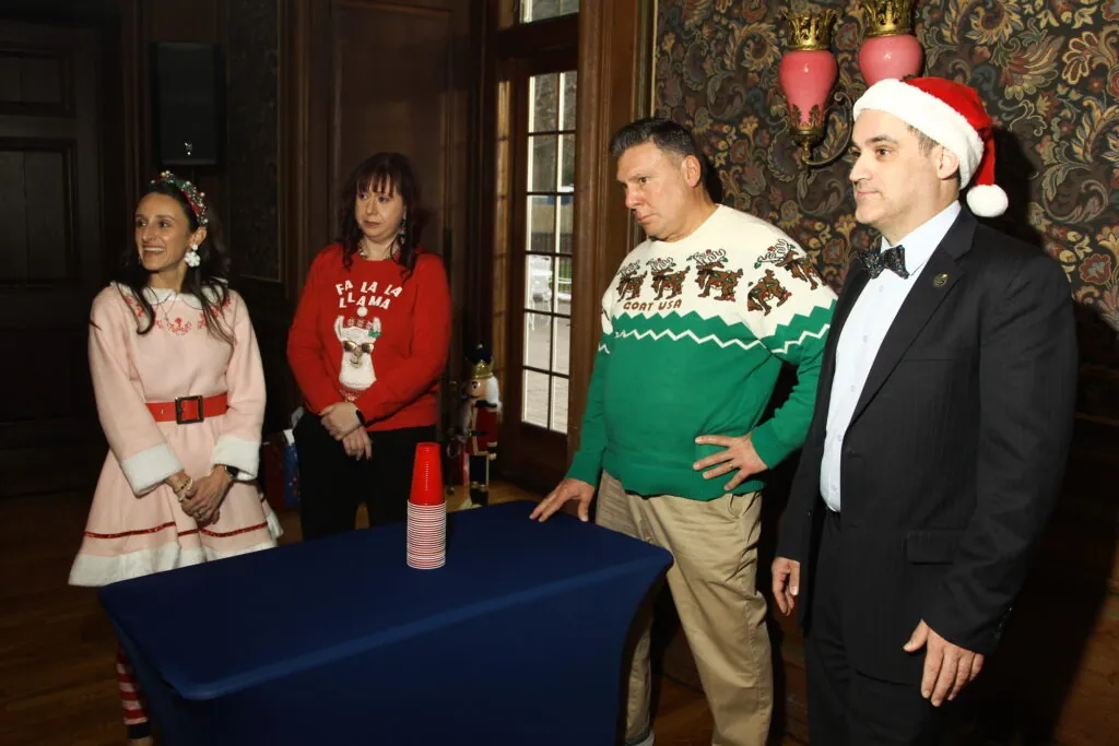 Teams compete in a Stack It Up holiday game at a corporate party in NYC