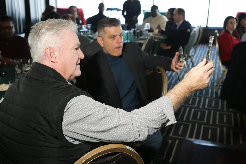 Guests at a corporate event using their phones to answer in an audience response game show