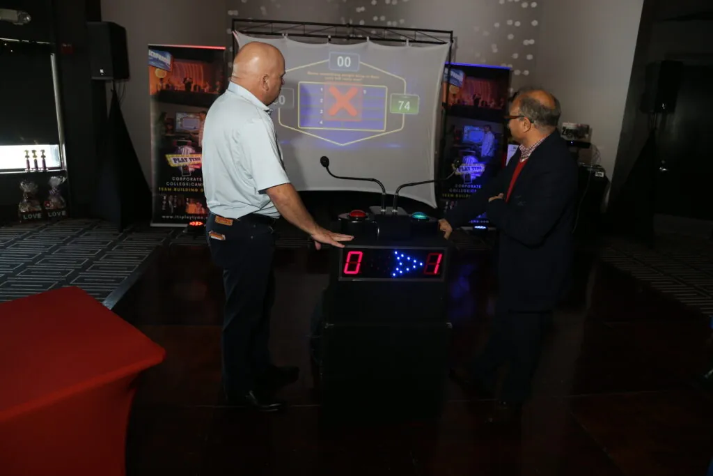 Feud game show buzzers and big screen set up for a corporate holiday party