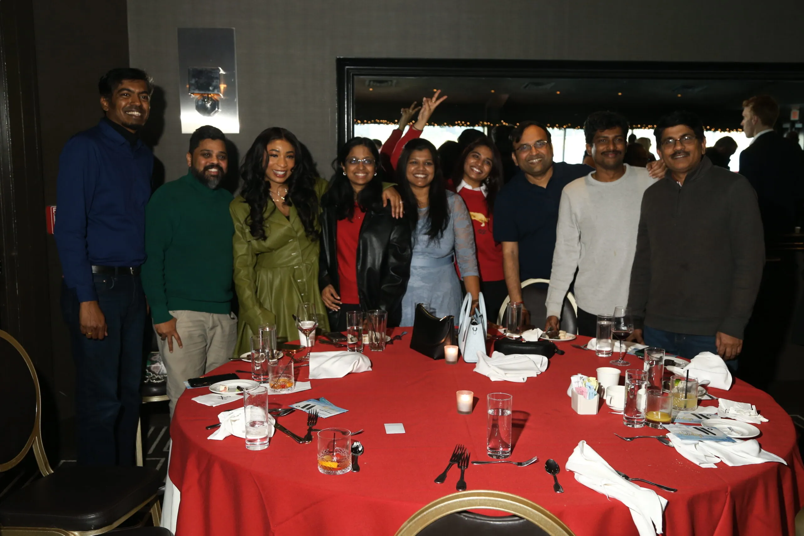 Corporate Christmas Party Venue Celebration Team members gather around red-draped tables at a corporate Christmas party game show