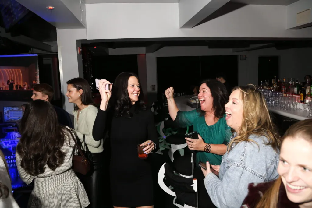 Guests cheer and play along during a hosted office holiday party game show